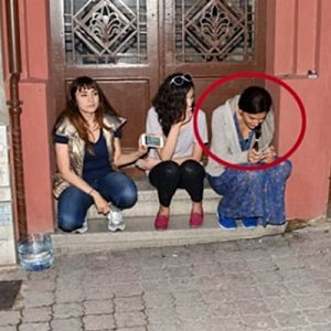 Sokak kenarındaki bir kaldırıma oturup arkadaşlarıyla sohbet ederken objektife yakalandı.